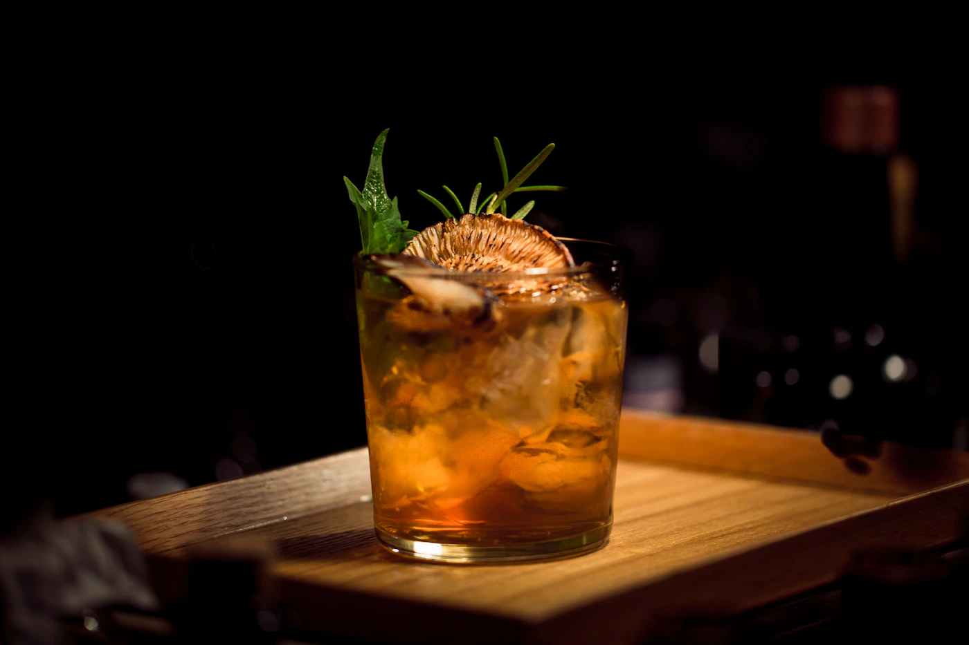Hands placing a citrus garnish on a cocktail